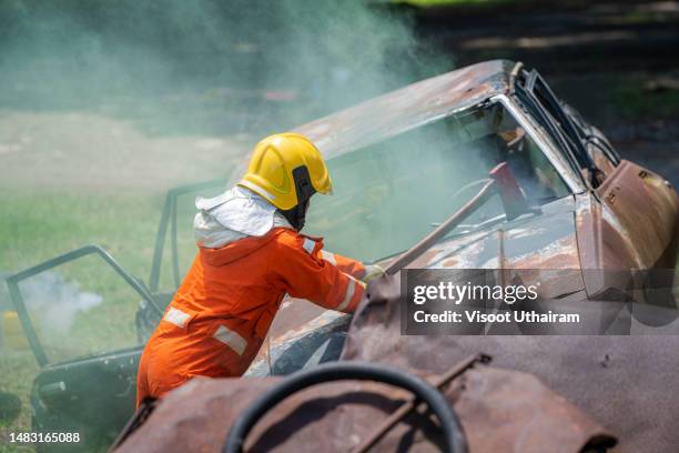 emergency fire rescue ,firefighters in uniform,emergency team rescue saving life in a car accident. - chassis stockfoto's en -beelden
