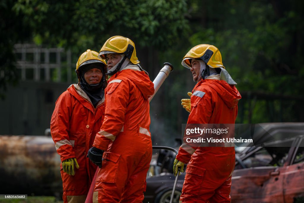 Firefighters spraying high pressure water to fire.