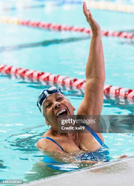 senior african-american woman swimming, celebrating - zwembadlaan scheidingslijn stockfoto's en -beelden
