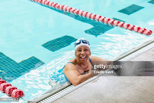 senior african-american woman at pool swimming laps - zwembadlaan scheidingslijn stockfoto's en -beelden