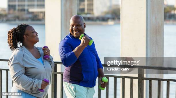 african-american couple power walking on waterfront - slightly overweight stock pictures, royalty-free photos & images