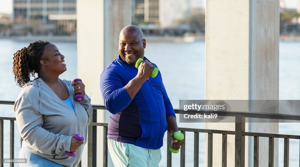 African-American couple power walking on waterfront