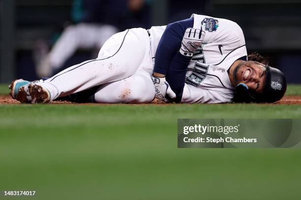 Eugenio Suarez of the Seattle Mariners reacts after he was hit by a pitch against Colin Rea of the Milwaukee Brewers during the third inning at...
