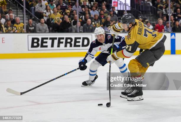 William Karlsson of the Vegas Golden Knights shoots and scores a goal under pressure from Brenden Dillon of the Winnipeg Jets in the second period of...