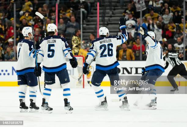 Adam Lowry of the Winnipeg Jets celebrates with teammates after an empty-net goal during the third period against the Vegas Golden Knights in Game...