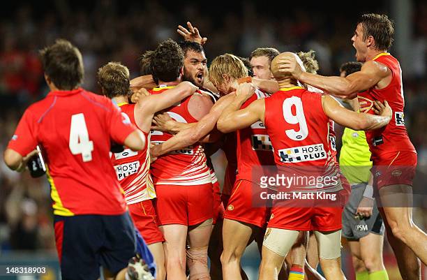 Karmichael Hunt of the Suns celebrates with team mates after kicking the match winning goal after the final siren during the round 16 AFL match...