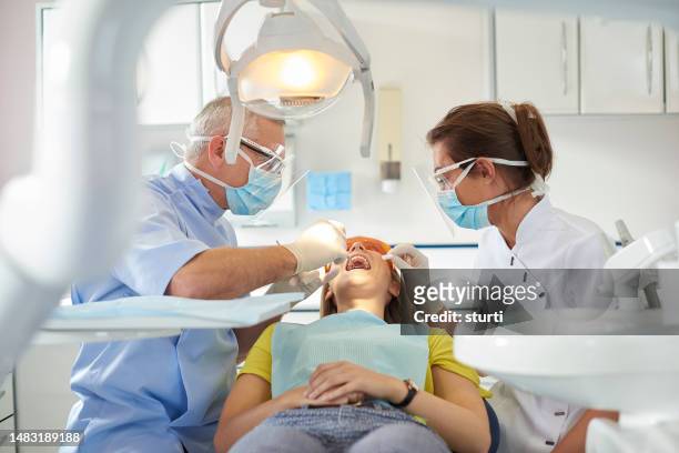 patientenuntersuchung des zahnärztlichen teams - a dentist stock-fotos und bilder
