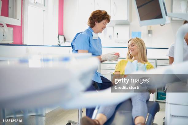female dentist explaining the treatment to patient - surgical mask and gloves stock pictures, royalty-free photos & images