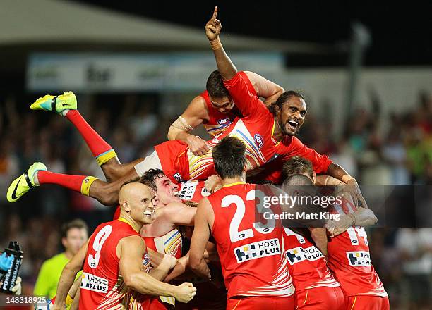 Liam Patrick of the Suns celebrates with Karmichael Hunt and team mates after Hunt kicked the match winning goal after the final siren during the...