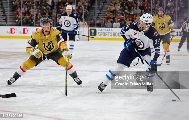 Morgan Barron of the Winnipeg Jets skates with the puck against Jack Eichel of the Vegas Golden Knights in the third period of Game One of the First...