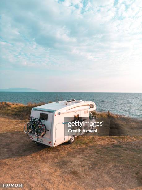 aerial view of motor homes on the beach at sunset in kanali, greece - camper trailer stock pictures, royalty-free photos & images