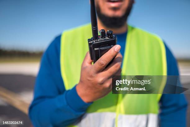 latin airfield operations officer communicating with air traffic control - waistcoat stock pictures, royalty-free photos & images