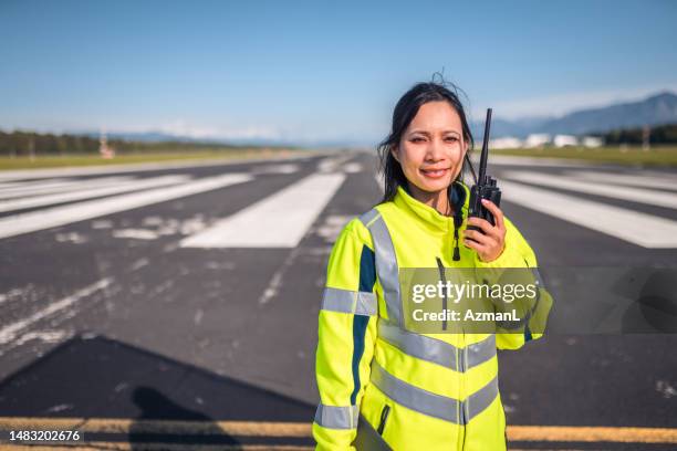 lateinischer flugplatzbetriebsoffizier, der eine situation mit walkie-talkie meldet - lotse stock-fotos und bilder