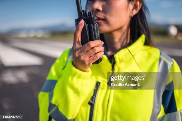 asiatische flugplatzbetriebsleiterin, die mit der flugsicherung kommuniziert - cb funk stock-fotos und bilder