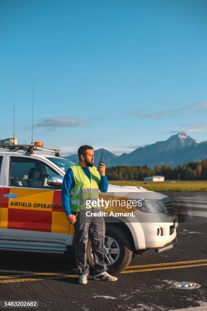 hispanic airfield operations monitoring aviation safety - airport ground crew uniform stock pictures, royalty-free photos & images