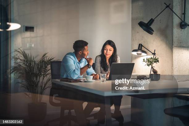 after hours at office, man and woman discussing plans - electronic organizer stock pictures, royalty-free photos & images