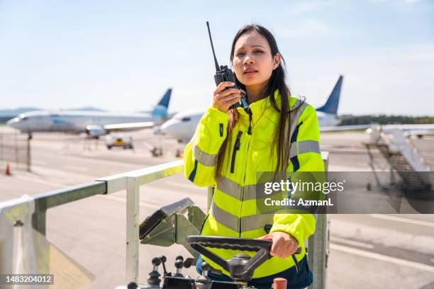 asian female airport worker operating a container transporter - transporter stock pictures, royalty-free photos & images