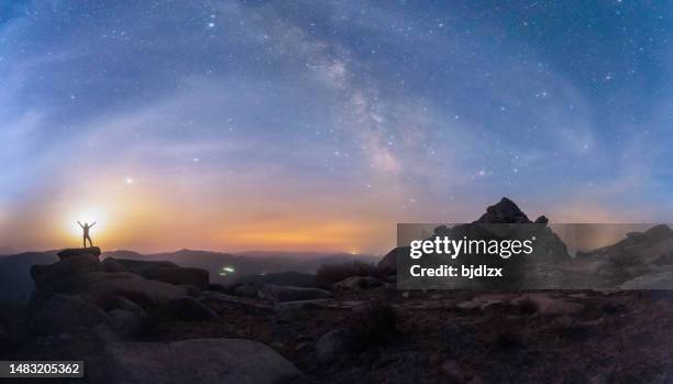 a young man on a mountain watching the milky way and lightning with a flash. - wide sky stock pictures, royalty-free photos & images