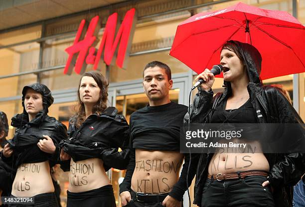 Young activists from the labor rights group ver.di show their stomachs with the words "Fashion Kills" written on them during a demonstration in the...