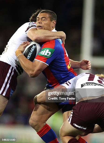 Timana Tahu of the Knights is tackled during the round 19 NRL match between the Newcastle Knights and the Manly Warringah Sea Eagles at Hunter...