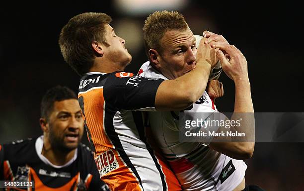 Luke Lewis of the Panthers is tackled during the round 19 NRL match between the Wests Tigers and the Penrith Panthers at Campbelltown Sports Stadium...