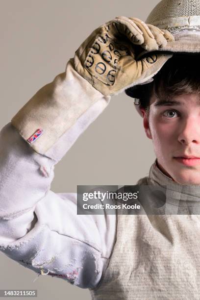 portrait of a teenage boy holding his fencing mask - face guard sport stock-fotos und bilder