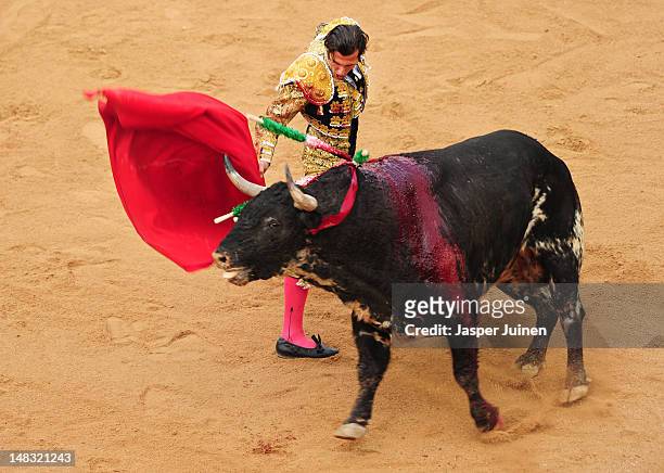 Bullfighter performs with a El Pilar fighting bull on the fourth day of the San Fermin running-of-the-bulls on July 10, 2012 in Pamplona, Spain.