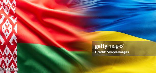 belarusian and ukrainian flags flutter together in the wind. - bielorrusia fotografías e imágenes de stock