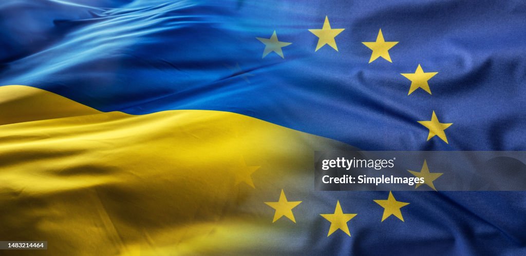 European Union and Ukrainian flags flutter together in the wind.