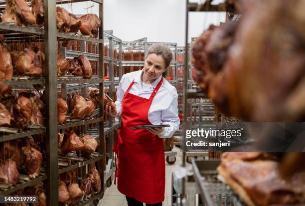 schlachthof und lebensmittelverarbeitung in der fleischindustrie - metzgerin stock-fotos und bilder