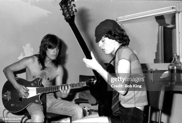 Malcolm Young and Angus Young of AC/DC, playing guitars backstage at the Hordern Pavilion, Sydney, Australia, 12th December 1976.