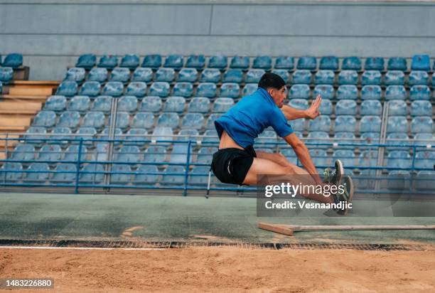 long jump, professional male athlete jumping on long distance - verspringen stockfoto's en -beelden