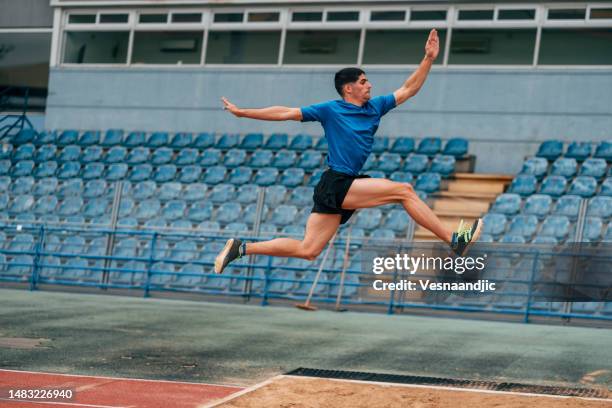 long jump, professional male athlete jumping on long distance - verspringen stockfoto's en -beelden