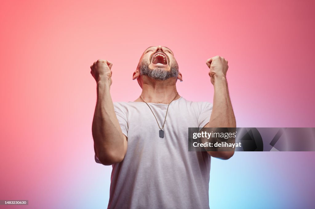 Man reacts intensely to something, screaming because of excitement of success or frustration and stress