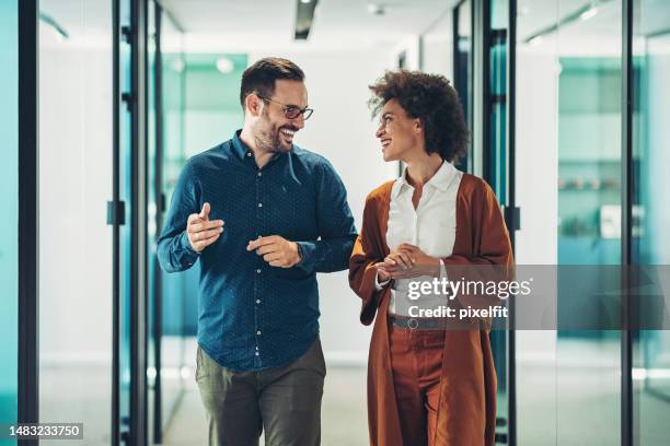 couple of business persons walking together and talking - 2 men woman imagens e fotografias de stock