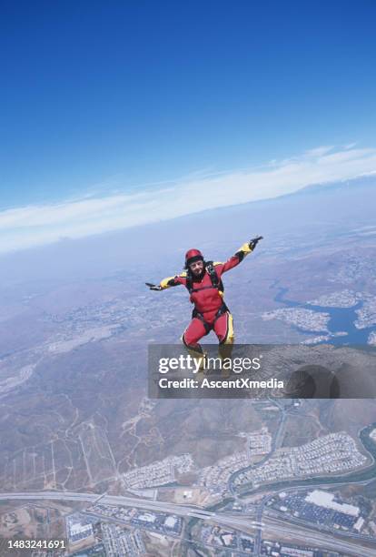 skydiver in free fall above urban area - parachute jump stockfoto's en -beelden