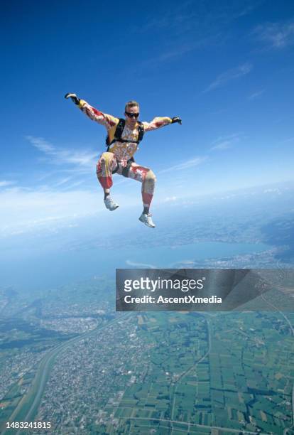 skydiver in free fall above mountains and urban area - super excited suit stock pictures, royalty-free photos & images