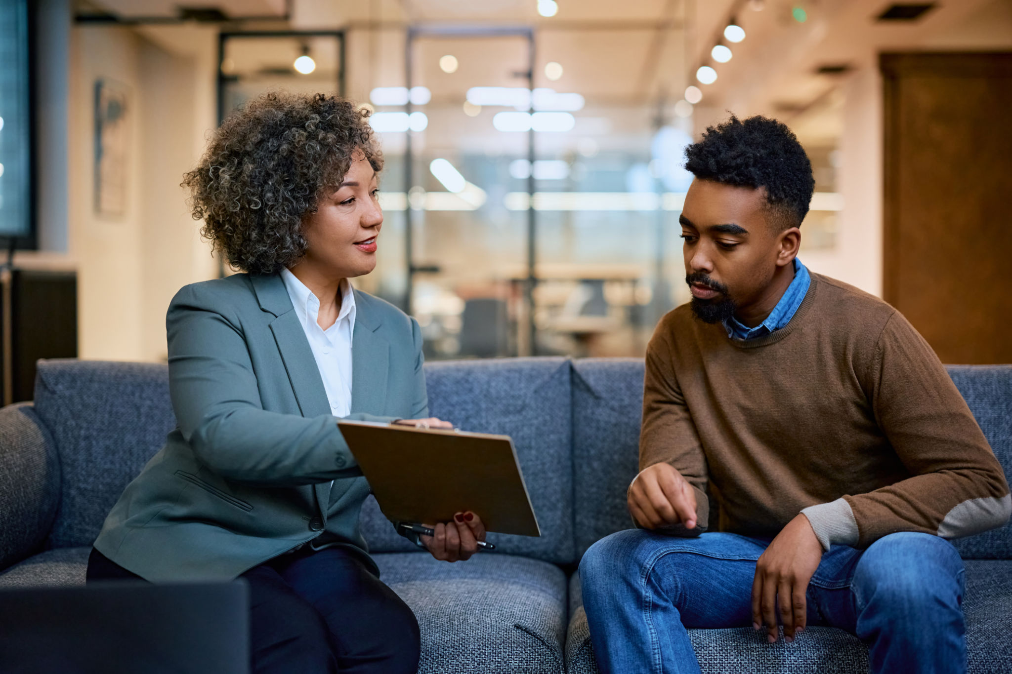 Financial advisor consulting African American man while going through paperwork on a meeting in the office. Financial advisor consulting African American man while going through paperwork on a meeting in the office.