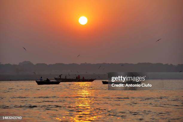 pilgrims on boats make offerings to the river ganges at dawn. varanasi - india - river ganges - fotografias e filmes do acervo