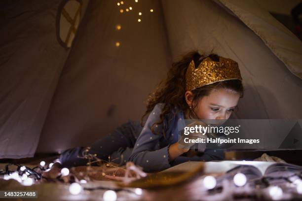 cheerful girl reading book at night. - princess bedroom stock pictures, royalty-free photos & images