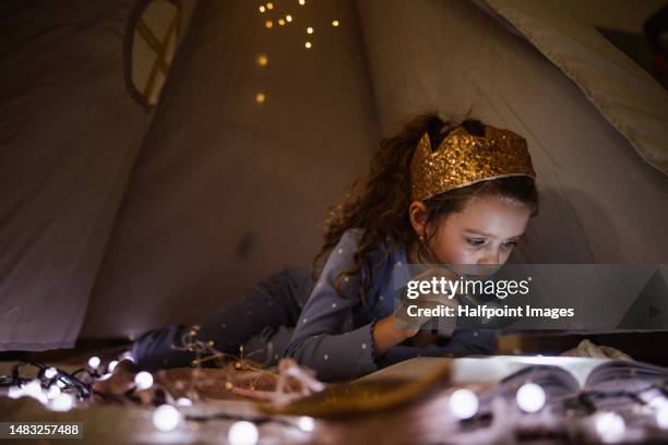 cheerful girl reading book at night. - girl princess stock pictures, royalty-free photos & images