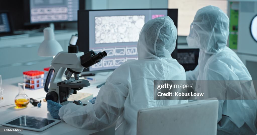Collaboration, science and computer with a doctor women team in a laboratory for covid research in ppe uniform. Teamwork, innovation and experiment with scientist females working together in a lab