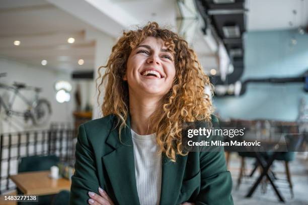 portrait of young business woman looking away, standing with arms crossed - teal portrait stockfoto's en -beelden