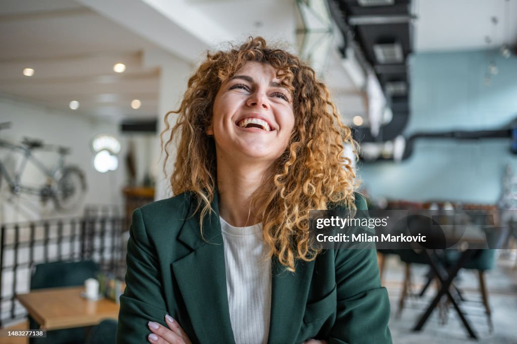 Portrait of young business woman looking away, standing with arms crossed