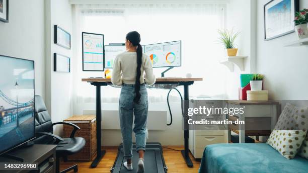 frau im home office läuft auf dem laufband unter dem schreibtisch - homeoffice stock-fotos und bilder