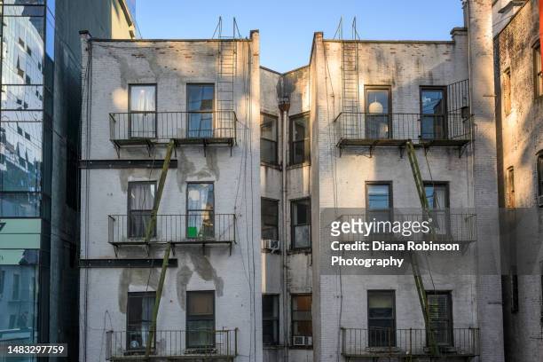 fire escapes and back view of old apartment houses along the high line on the west side of manhattan. - diana center stock pictures, royalty-free photos & images