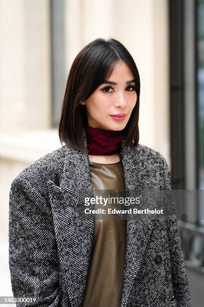 Heart Evangelista wears a red burgundy wool small scarf, a khaki brown shiny leather short dress from Hermes, a black and white striped print pattern...