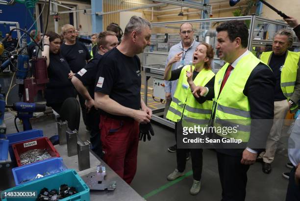 German Labour and Social Affairs Minister Hubertus Heil speaks, with the help of a sign language interpreter, with a deaf employee at a Siemens...