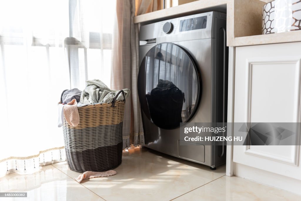 Basket with dirty laundry on floor at the window at home