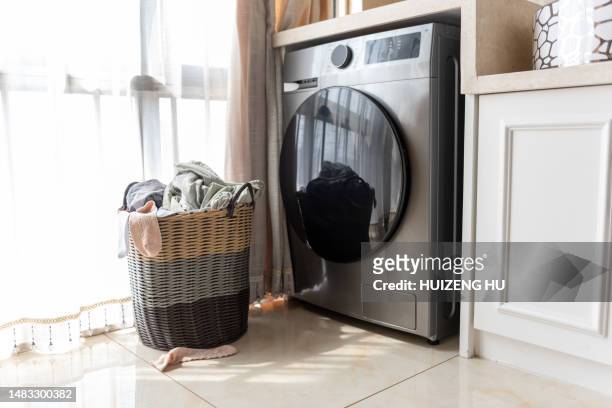 basket with dirty laundry on floor at the window at home - secador de roupas imagens e fotografias de stock